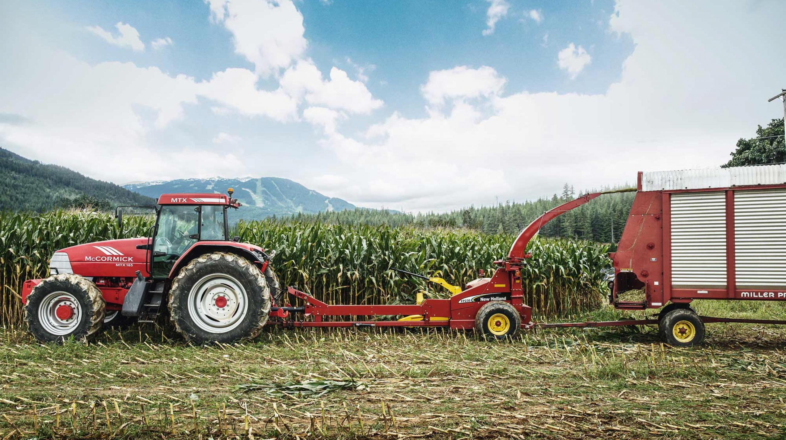 Tractor with pull behind harvester Tractor with pull behind harvester harvesting corn